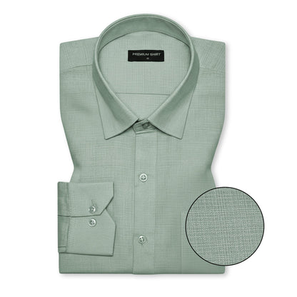 Folded green dress shirt with close-up detail on a white background