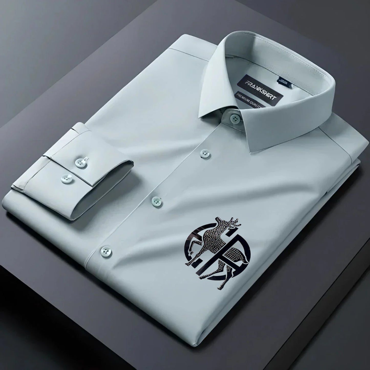 Folded light gray dress shirt with a logo on a dark surface