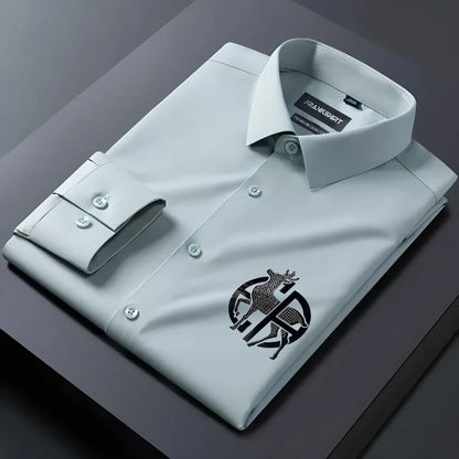 Folded light gray dress shirt with a logo on a dark surface