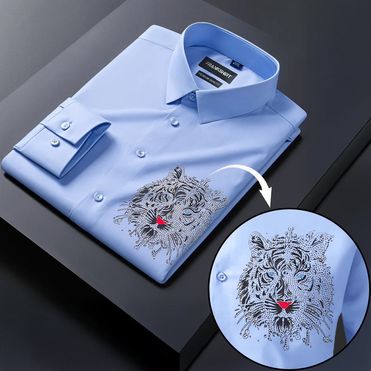 Folded light blue shirt with tiger embroidery on a dark surface