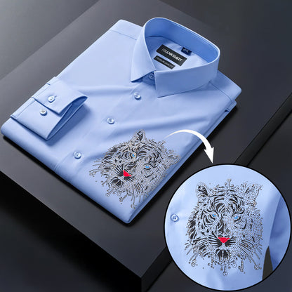 Folded light blue shirt with tiger embroidery on a dark surface