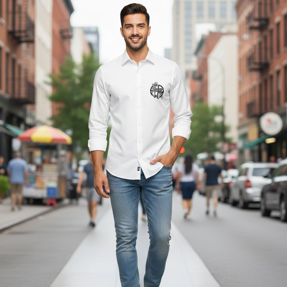 Man in a white shirt with a logo walking on a city street.